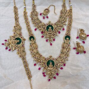 Antique Gold Plated Lakshmi Motif Haram, Necklace, Jhumka Earrings, Maang Tikka & Vaddanam (Red & Green Kemp Stones)