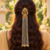 Bride wearing South Indian peacock Jada Billa with ruby green stones and long pearl chains over a half-up half-down hairstyle.