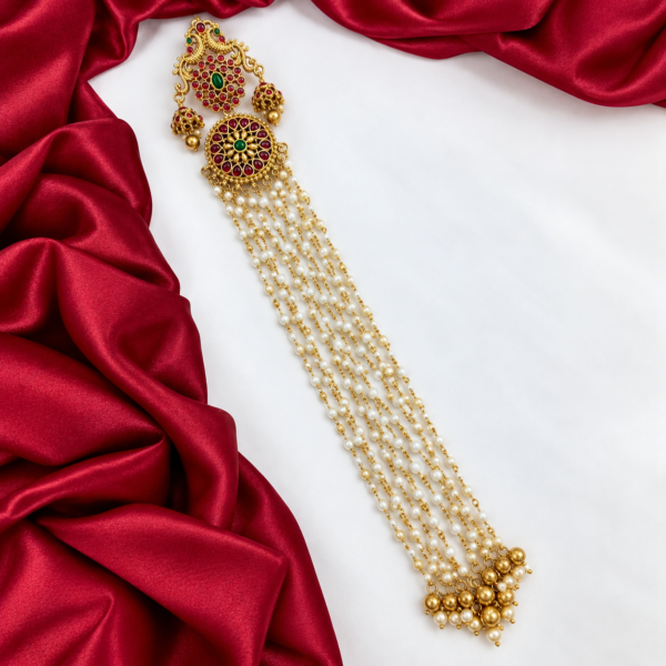 South Indian peacock Jada Billa hair choti with ruby green stones, circular floral ornament and long white pearl-beaded chains.