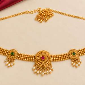 Traditional South Indian gold finish Kamarpatta waist belt with circular floral motifs, ruby green stones and pearl-style hanging drops.